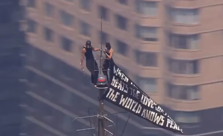 Dos personas suben a la cima del Empire State Building con una pancarta a favor de la paz